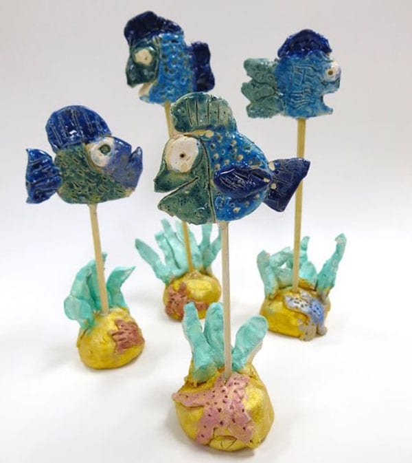 Clay fish mounted on sticks stuck into clay bases