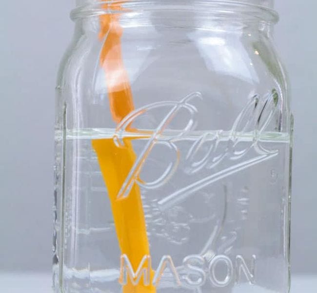 Mason jar of water with a pencil in it, viewed from the side
