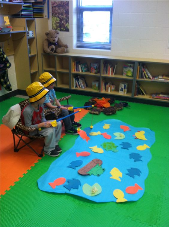 Two Children are shown playing a fishing game in a classroom setting.
