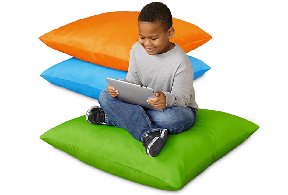 Student sitting on giant cushion with two others for flexible seating