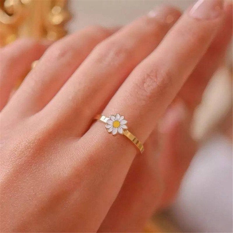 Hand wearing fidget ring with spinning daisy top
