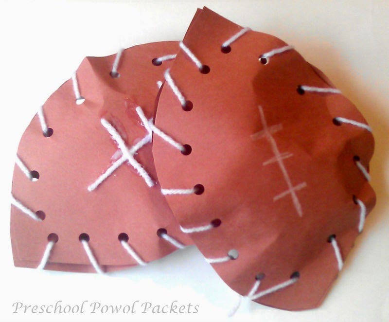 Paper footballs made by sewing two pieces of construction paper together with yarn