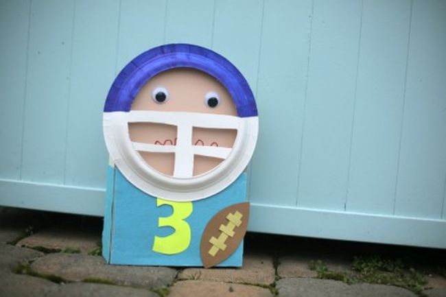 A football player puppet made from a cereal box and paper plate