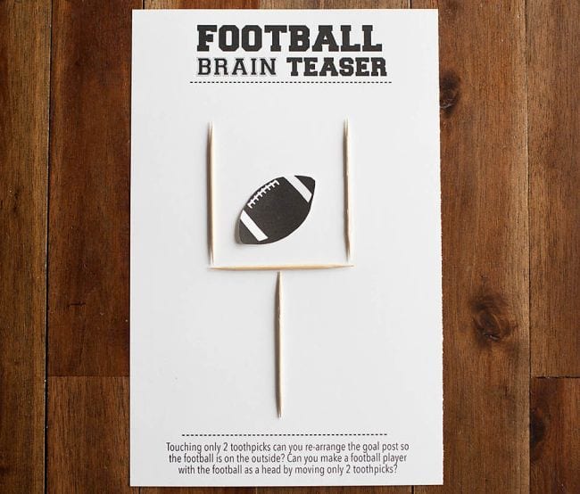 Goalpost made from 4 toothpicks laid on top of a worksheet with a football printed on it