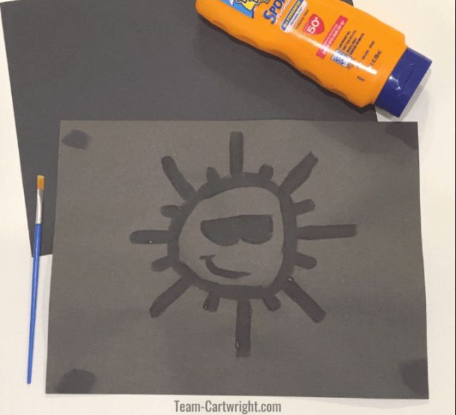 Sun painted onto a piece of black construction paper using sunscreen