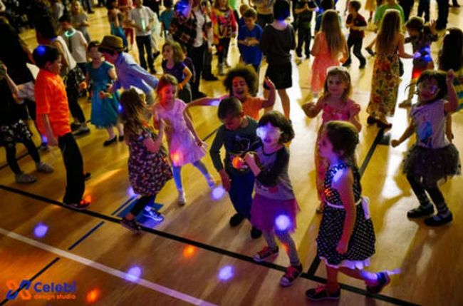 Young students dancing with colored lights