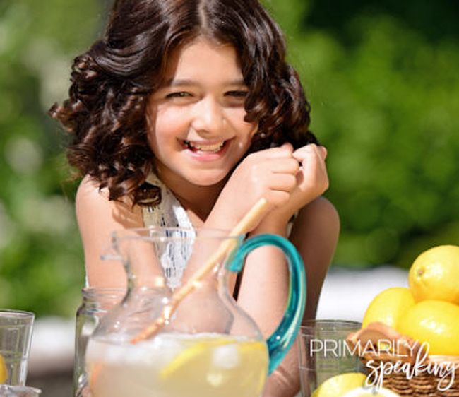 Student holding a cup with a pitcher of lemonade and some lemons as an example of fun last day of school activities