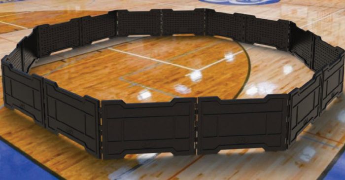Gaga ball pit made of black plastic panels sitting on a gymnasium floor