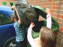 Students throwing away trash bag