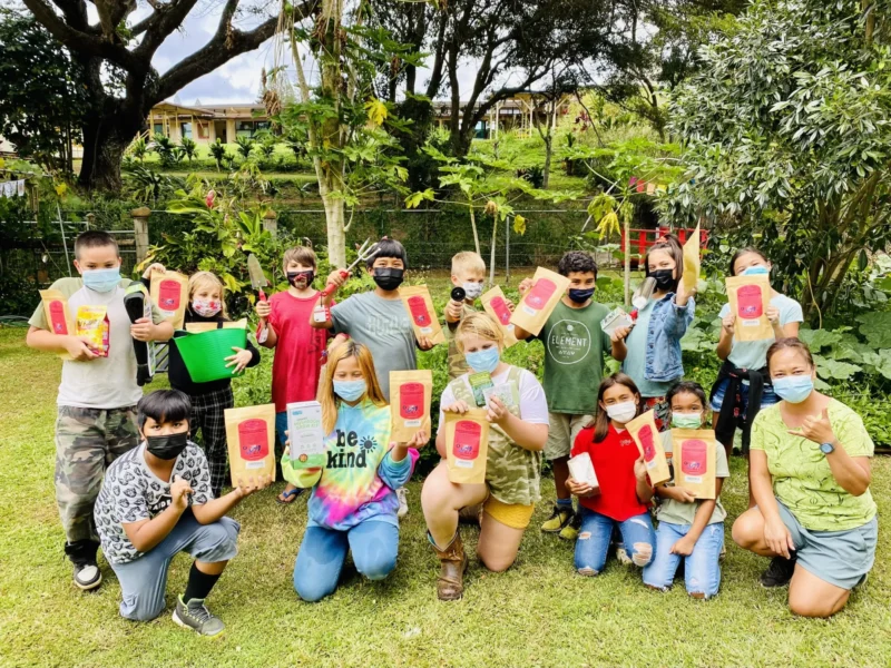 students and teachers in a group holding a gardening grant award for an idea to make a school greener 