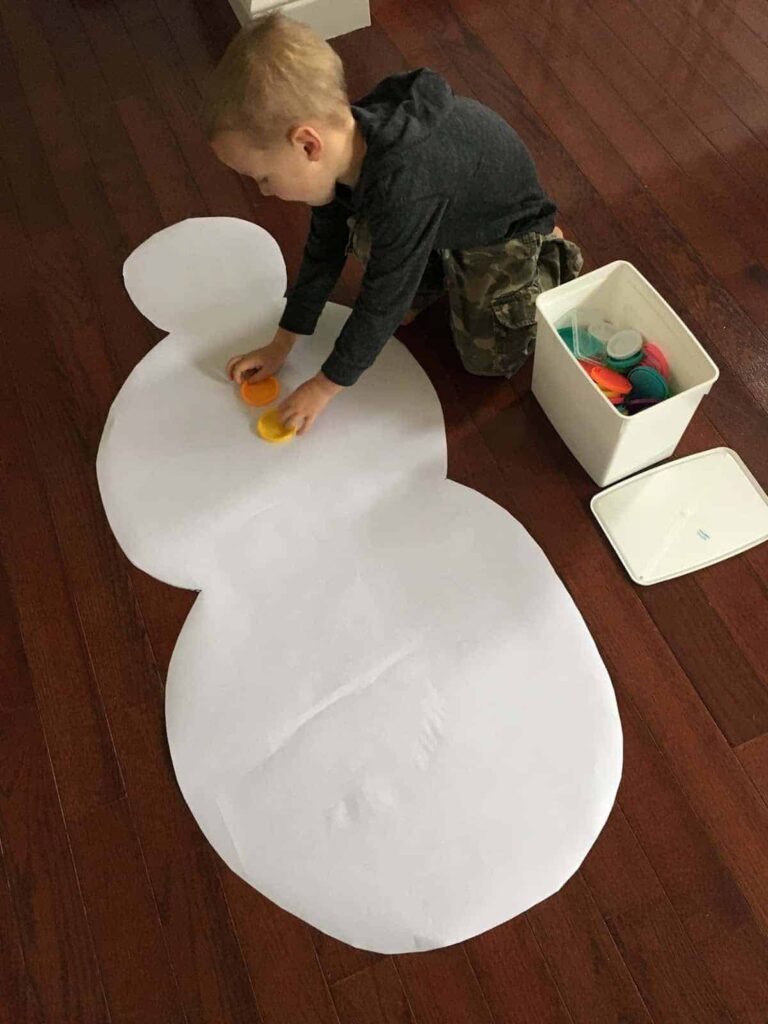 boy making a giant paper snowman 