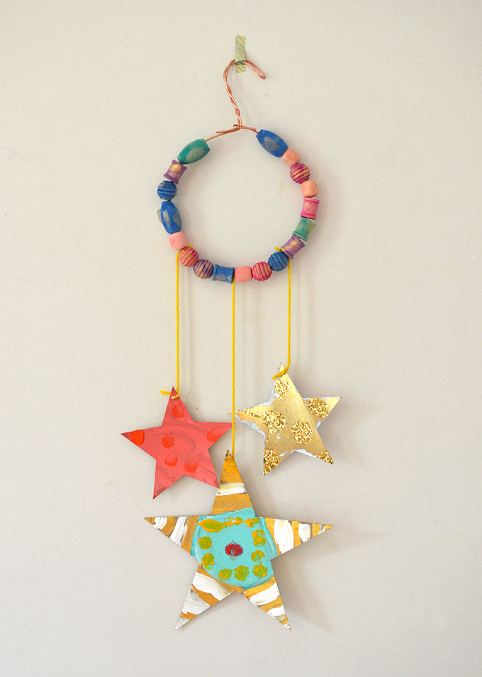 Glittery hand made stars dangle from a beaded copper wire