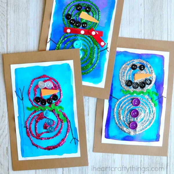 Painted snowmen using swirly glitter glue and buttons.