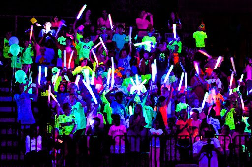 Students in a black-lit room wearing neon clothing