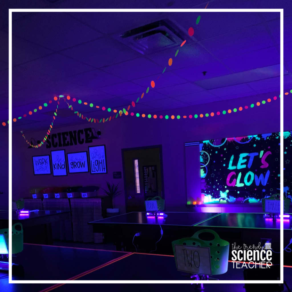 A classroom is lit by a black light and glowing strings of light as an example of fun last day of school activities