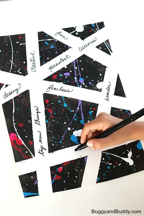 white strips separate black shapes with bright paint splatterd on them. A hand is seen writing words on the white areas.