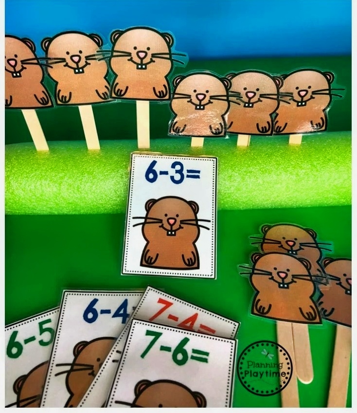 Paper cut outs of gophers are glued to a craft stick and inserted into a pool noodle as an example of subtraction activities
