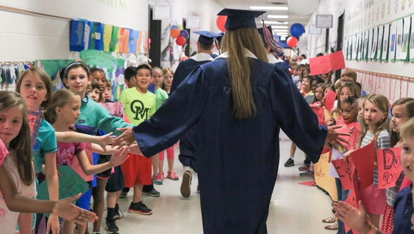 high school graduates walking through the halls of their elementary school