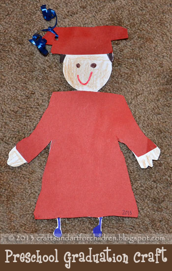 A graduate wearing a red cap and robe is made from construction paper and crayons.