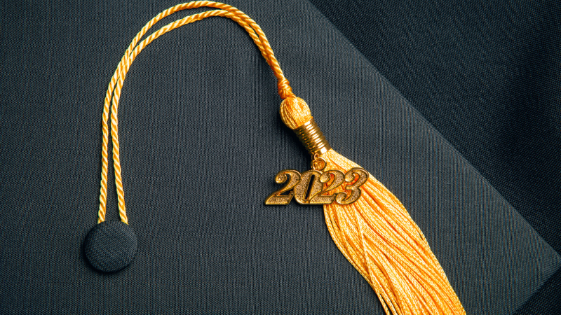 Black graduation cap with gold tassel and 2023 charm.