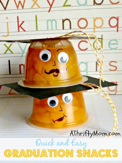 Two fruit cups are stacked on top of each other and have googly eyes and little faces drawn on them. A black piece of paper and tassel complete the edible graduation cap.