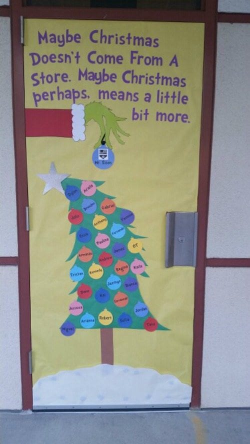 Classroom door decorated with a Christmas tree and Grinch hand holding an ornament. Text reads "Maybe Christmas doesn't come from a store. Maybe Christmas perhaps means a little bit more."