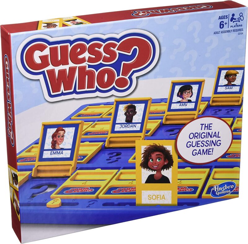 A game board has cards facing up with names and cartoon faces on them. Text reads Guess Who?