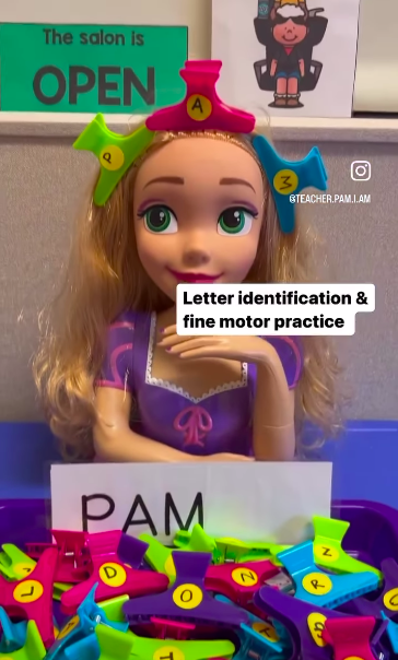 A large doll with colorful hair clips labelled with letters in her hair as an example of dollar store hacks for the classroom 