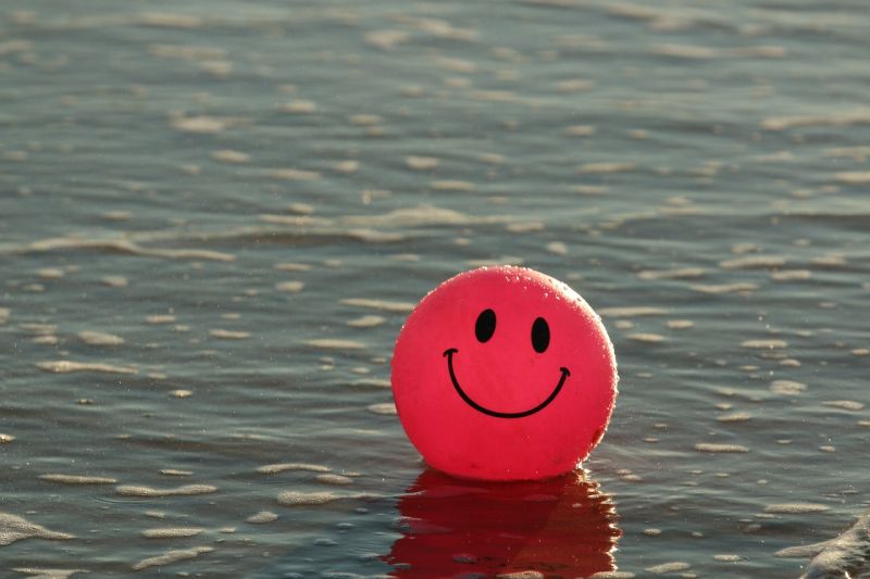 A red ball with a smiley face floating on the water