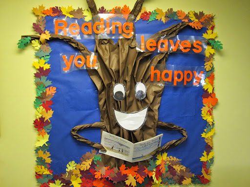 Bulletin board with "Reading leaves you happy" and a decal of a tree on it