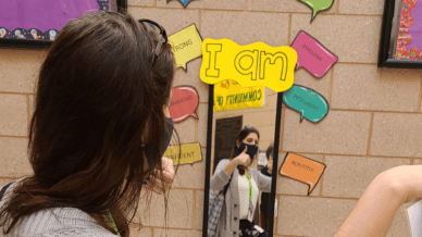 Teacher looking in a mirror surrounded by affirmations