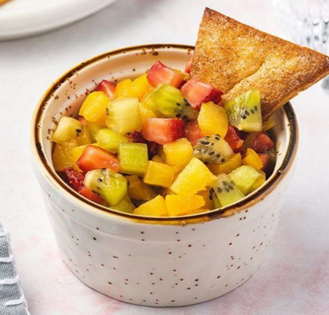 Small dish of fruit salsa with cinnamon pie crust chip