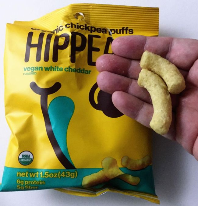 Hand holding two Hippeas cheese puffs (Healthy Snacks for Kids)