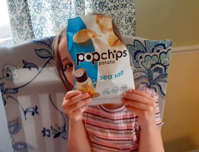 Child holding an opened bag of Popchips (Healthy Snacks for Kids)