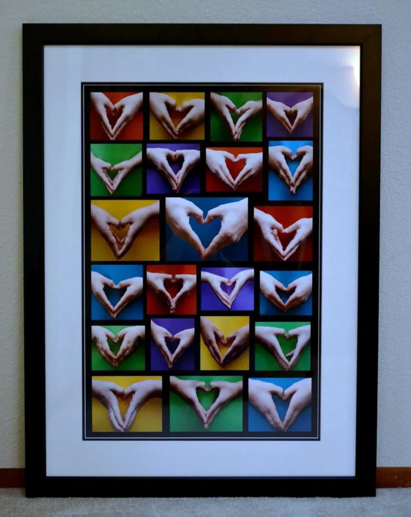 A framed collage of childrens' hands in the shape of hearts as an example of a school auction art project