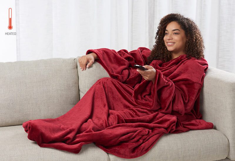 Woman on a couch with red wearable blanket