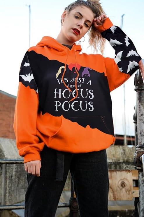 A woman is shown wearing an orange sweatshirt with a big black block across it that says It's Just a Bunch of Hocus Pocus. There is an outline of the hair and hats of the three witches from the movie.