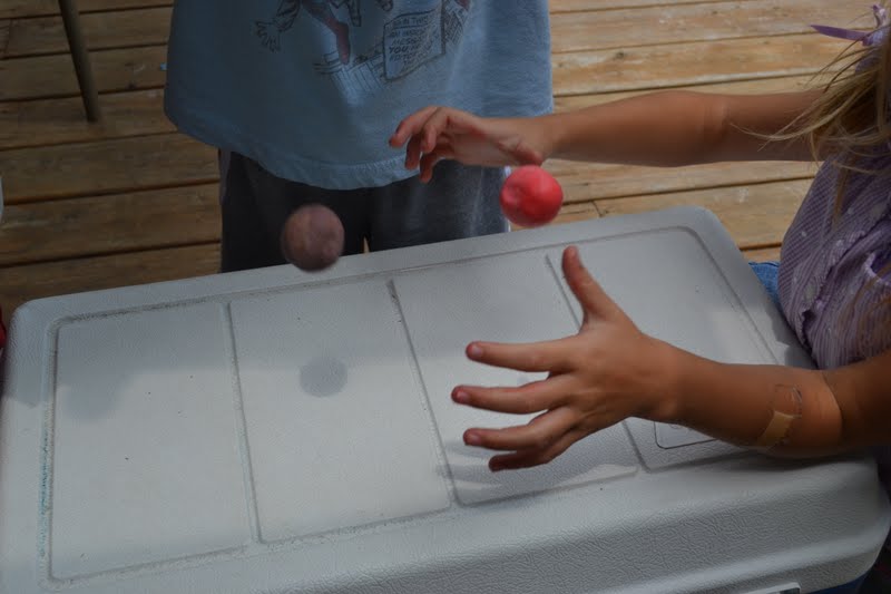Two children are shown (without faces) bouncing balls on a white table (easy science experiments)