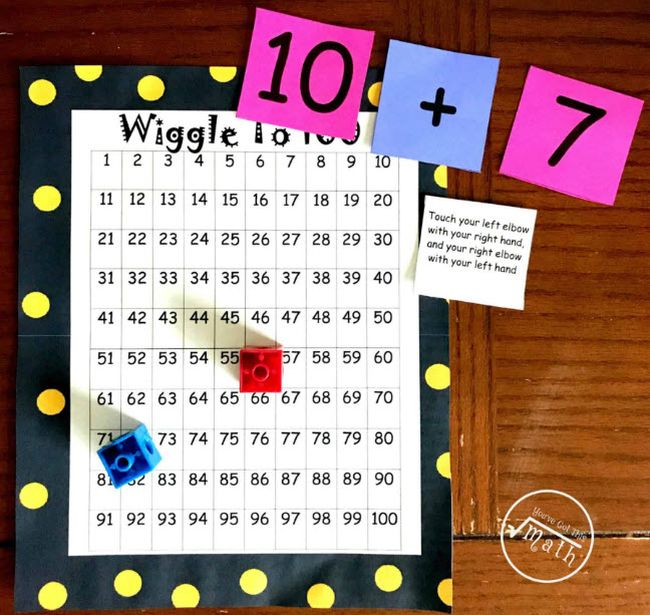 Hundreds chart labeled Wiggle to 100, with number cards reading 10 + 7, a set of dice, and a card describing a physical activity to be completed