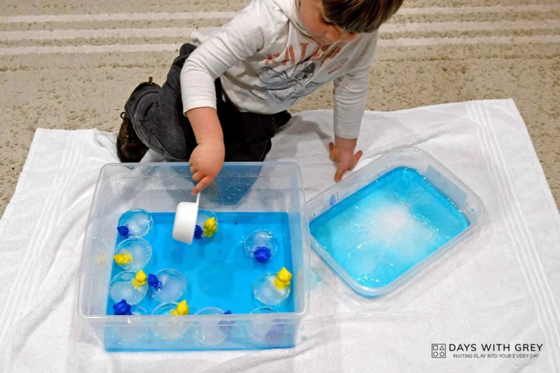boy playing with winter sensory bin for fun winter activity 