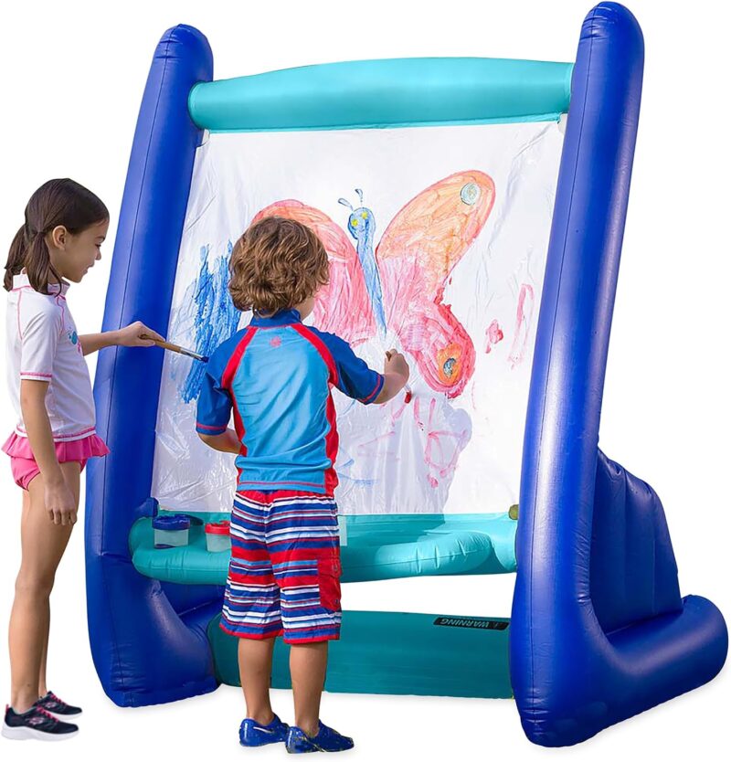 Two kids in bathing suits stand in front of a huge inflatable art easel for kids painting a butterfly.