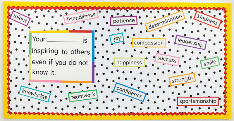 Bulletin board with yellow border and black and white polka dots that has inspirational words on it.