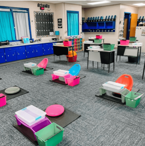 Instead of desks, small, low to the ground areas are designated for students in this classroom. 