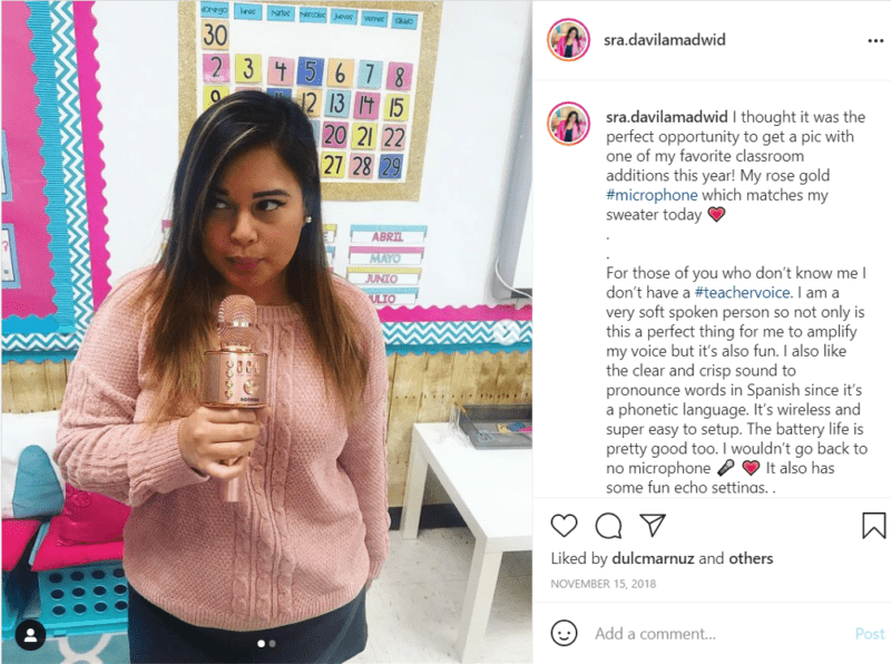 Teacher holding rose gold microphone in Spanish classroom