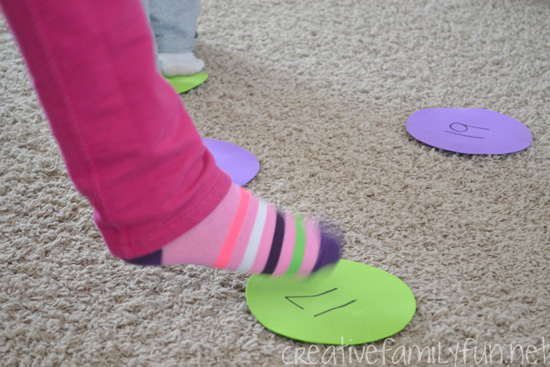 child's foot stepping on a number on the carpet for a math facts game