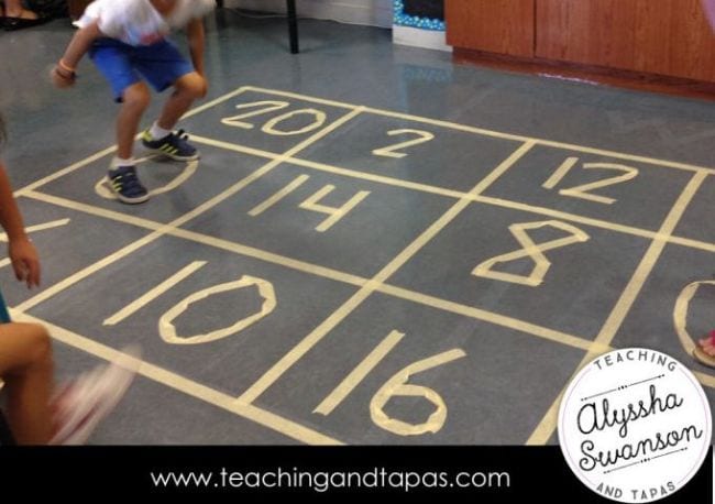 numbers made of tape on the ground and a child jumping on them