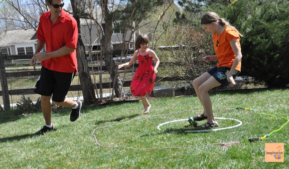 Kids playing kick the can in yard.