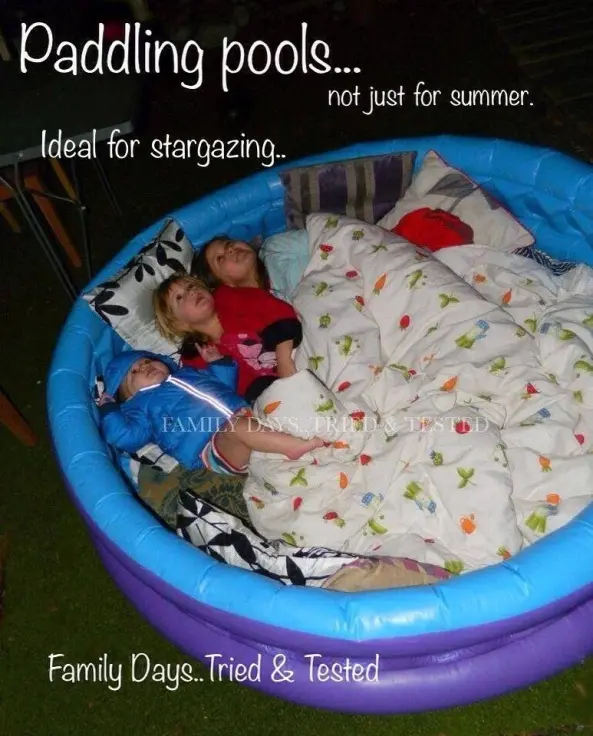 Kiddie pool games don't even have to be a game. This kiddie pool is filled with blankets and pillows and kids are laying down inside stargazing.