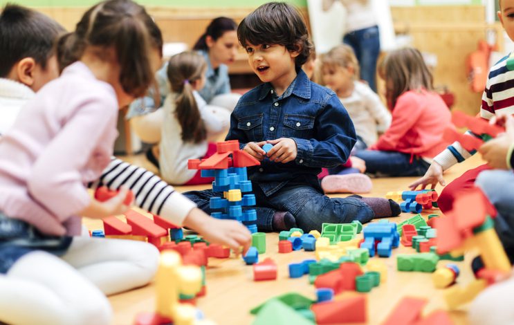 Kids on the floor building with blocks