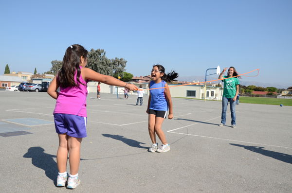 Recess games can use jump ropes like the one shown being used by three girls.